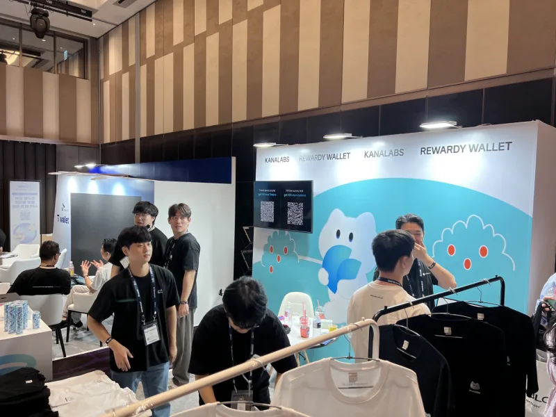 Photograph of the Kana Labs and Rewardy Wallet booth at Korea Blockchain Week 2024 with visitors present